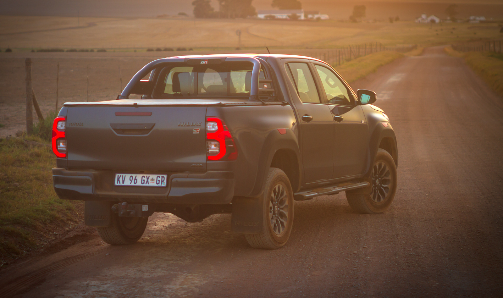 Toyota Hilux GR-S (GR-Sport) rear three-quarter view in rural location.