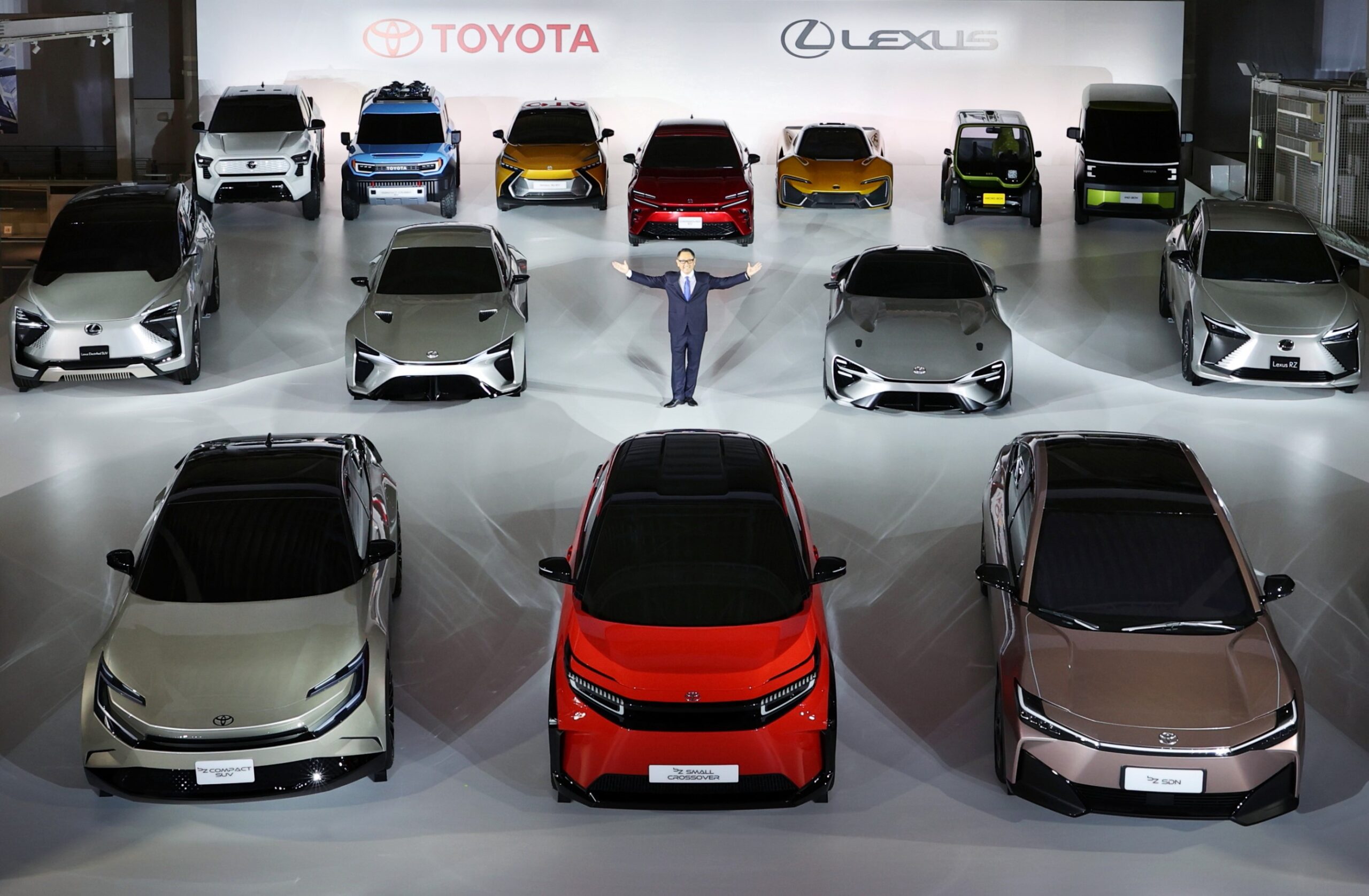 Akio Toyoda stands in the centre of a a room full of Toyota concept models.