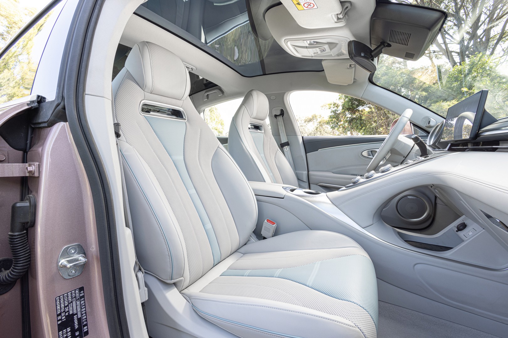 Contoured sports seats of the GWM Ora Sport. Also pictured: floating centre console with metallic knobs.