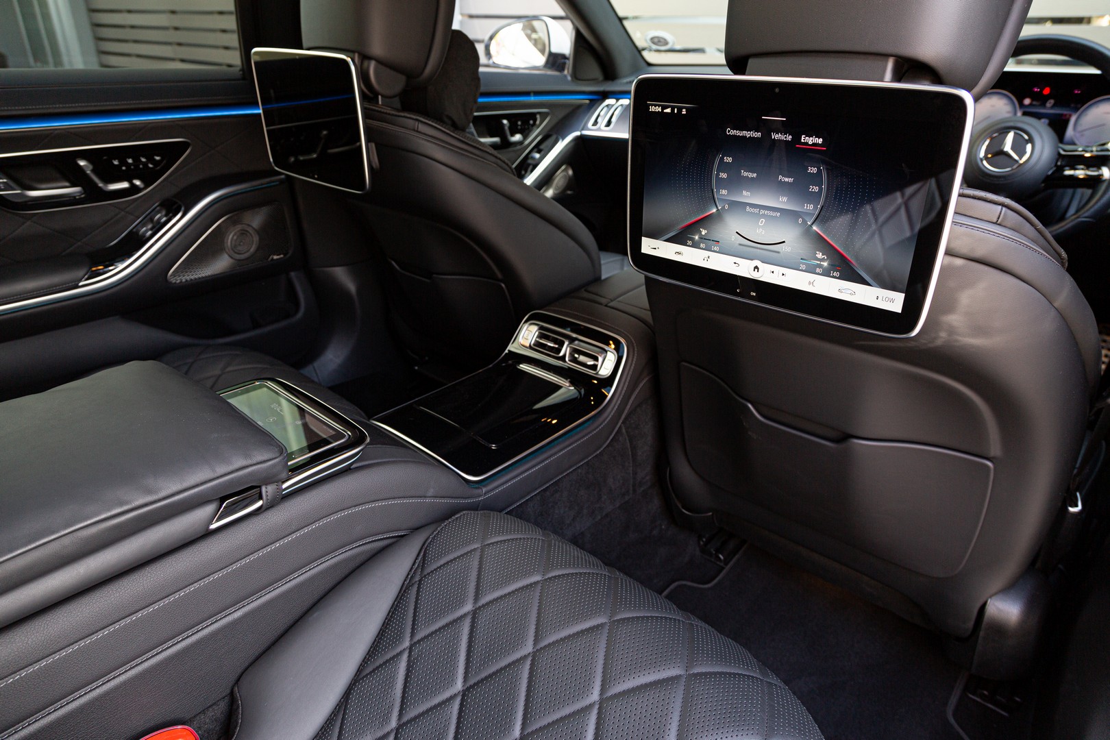 Airline-like leather seats with electric adjustment buttons, trimmed centre console and infotainment system of the W223 Mercedes-Benz S-Class. 