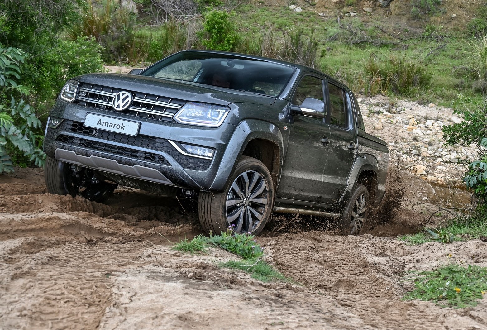 First-generation Volkswagen Amarok scaling a muddy incline.