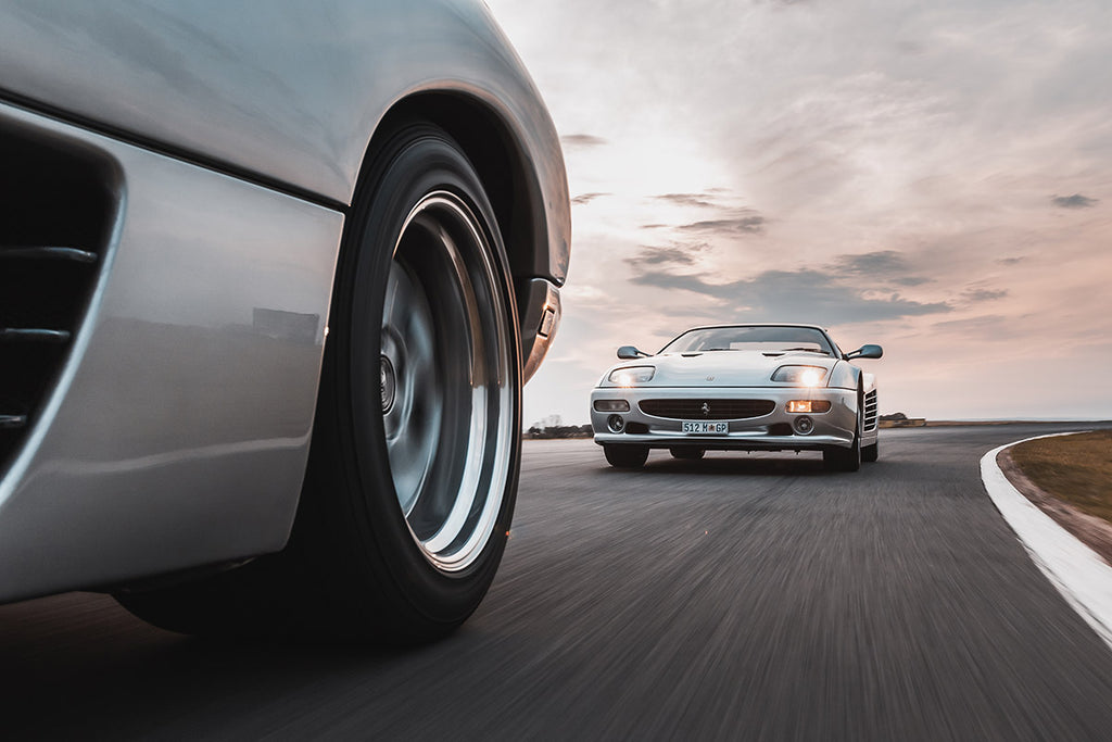 Lamborghini Diablo (left) and Ferrari F512 M cornering on a race track.