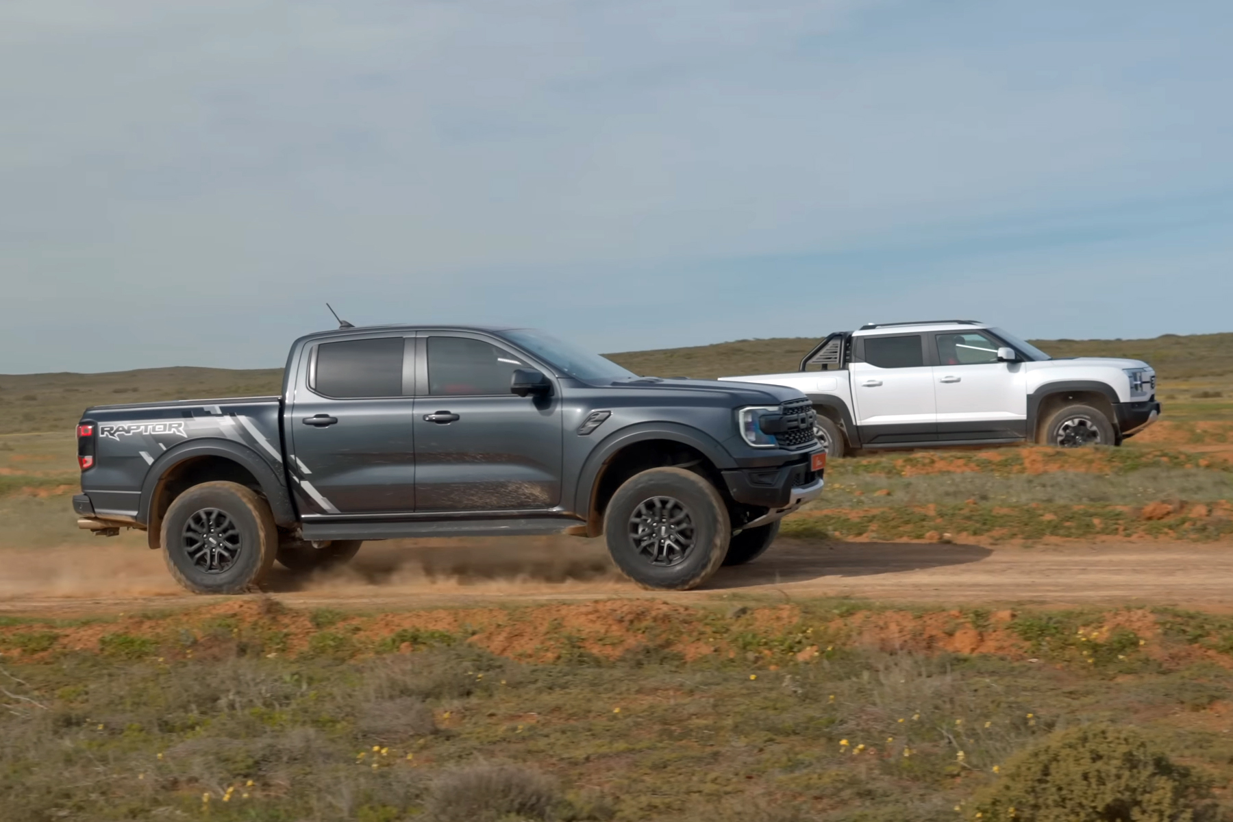 Ford Ranger Raptor (left) flanked by BYD Shark 6 panning shot