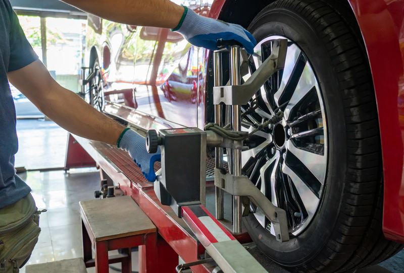 a mechanic check wheel alignment and balancing on a car